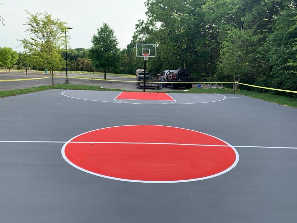 Resurfaced basketball court in red and grey