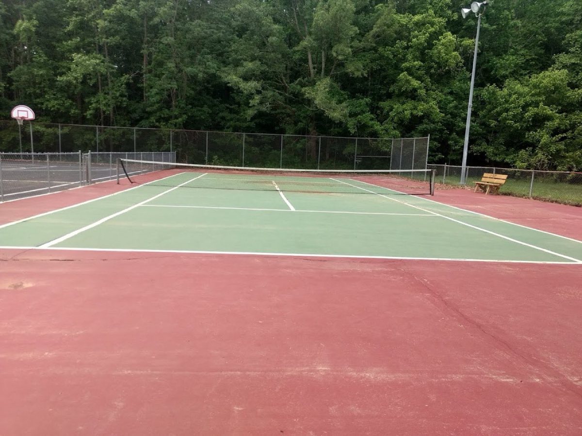Faded red and green tennis court before resurfacing