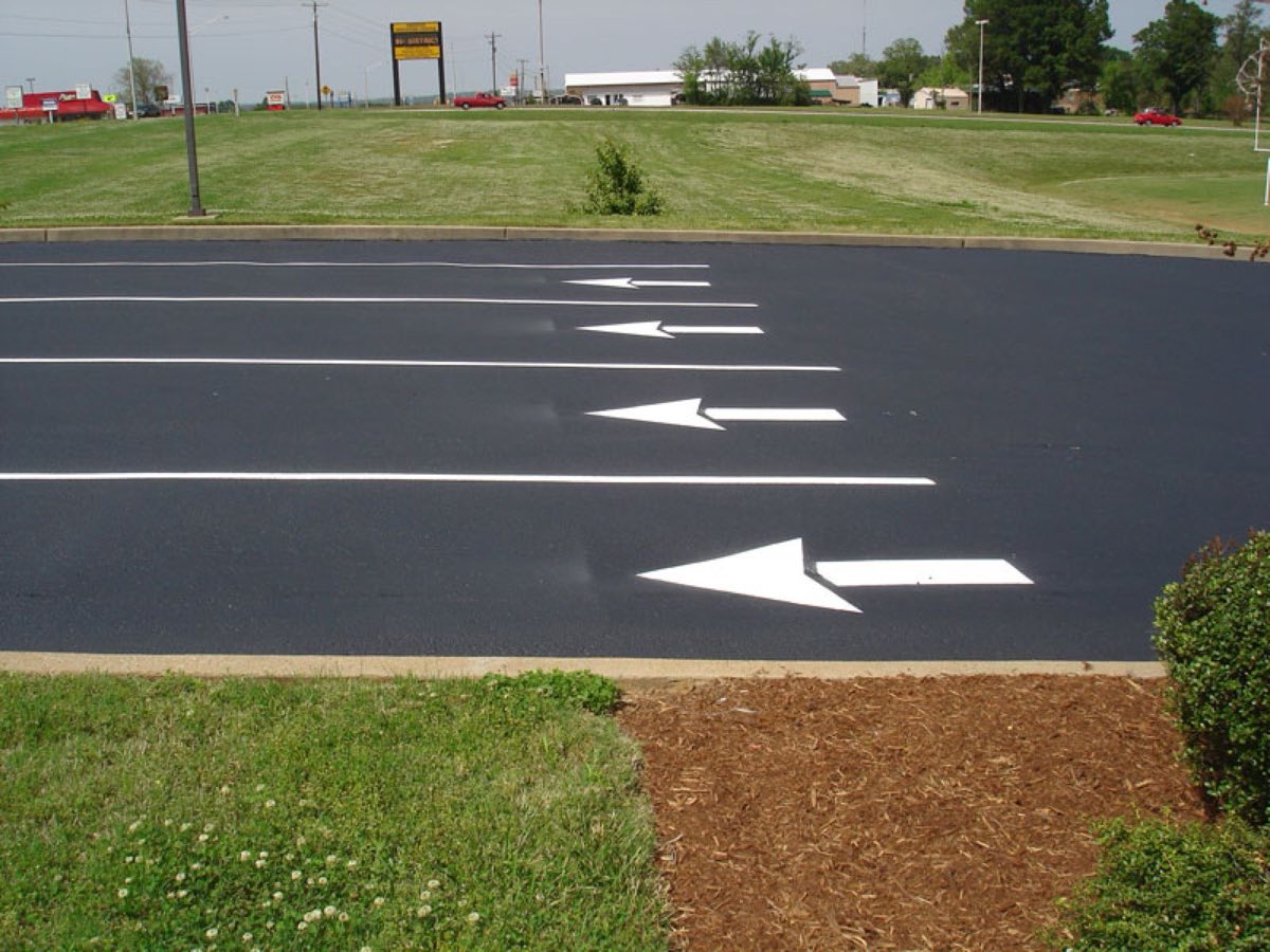 Freshly sealcoated and striped parking lot with directional arrows